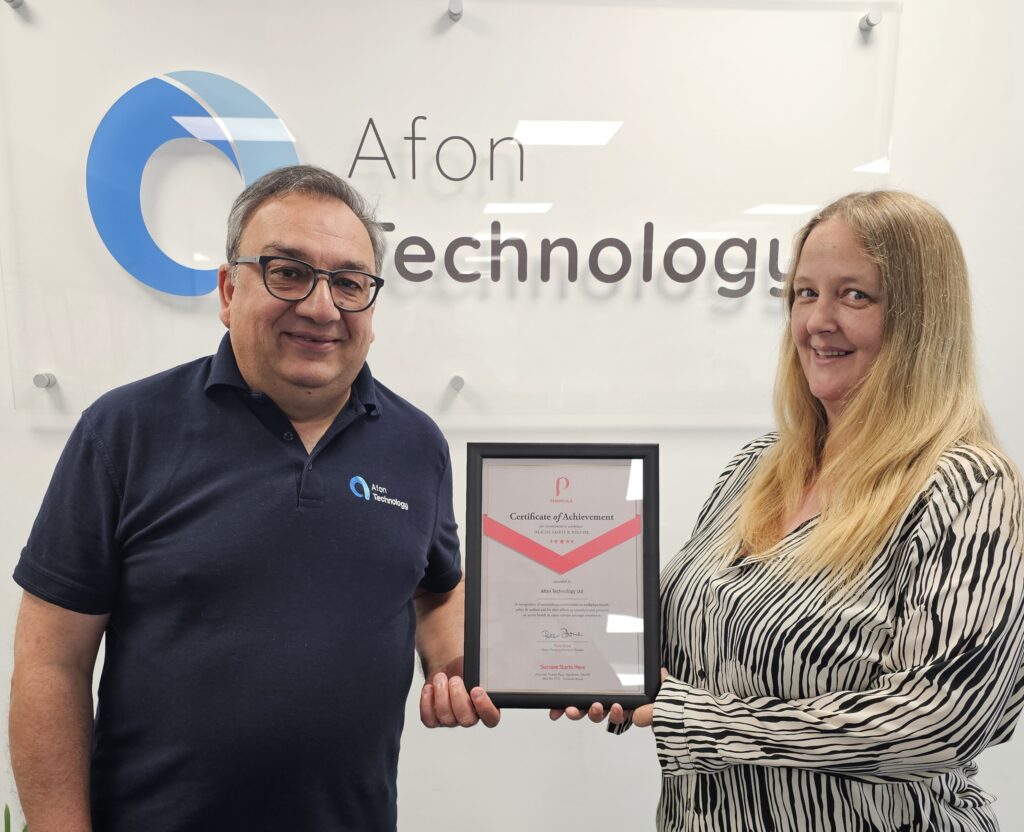 Sabih Chaudhry and Maddie Wilson hold a framed certificate of the Peninsula Health and Safety Gold Award