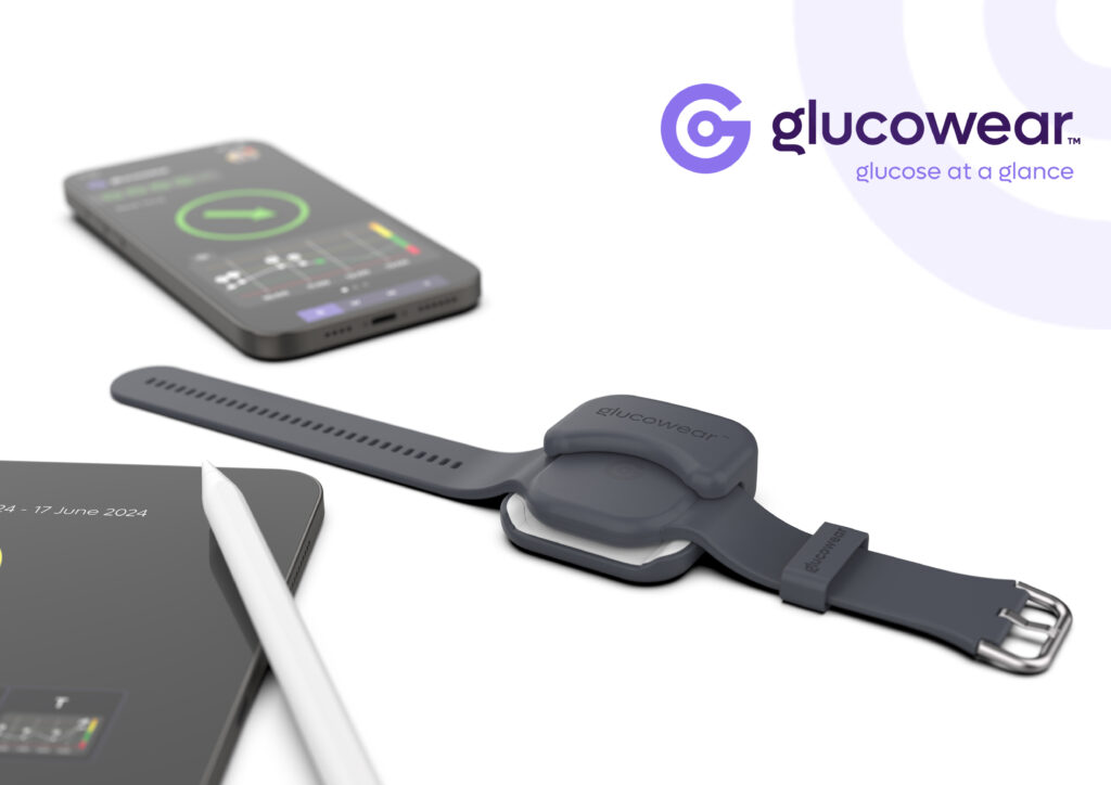 European Product Design Award Personal/Wellness and Beauty: Other Designs category winner Glucowear by Afon Technology - Glucowear looks like a rounded square device about the size of 50p coin with straps similar to a smart watch. It is black with a silver buckle and sits in a charging port that is only a little bigger than the device. The port envelopes half of the sensor. Glucowear sits next to a smartphone with glucose readings on in the form of charts. 